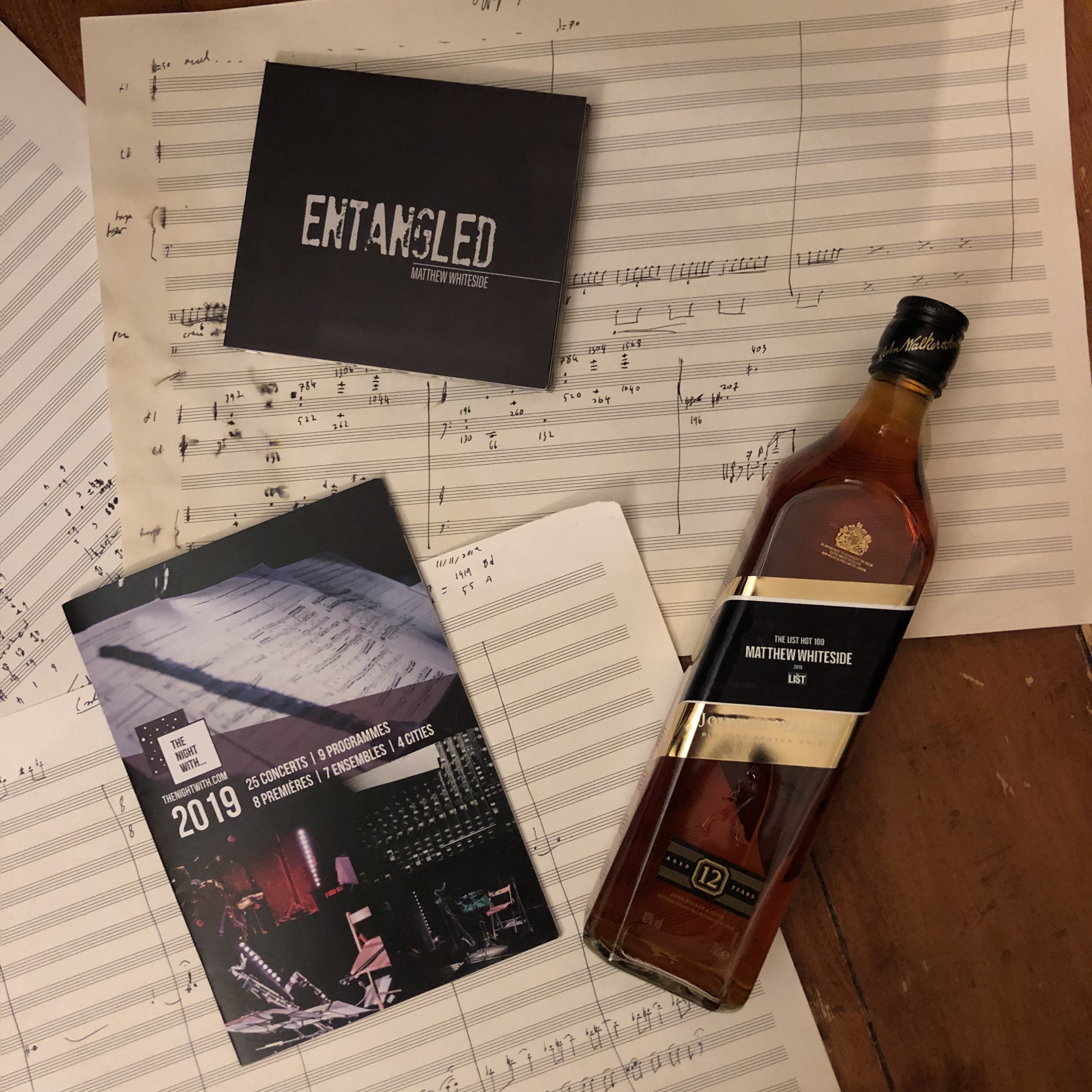 whiskey, cd, and season brochure on sheet music